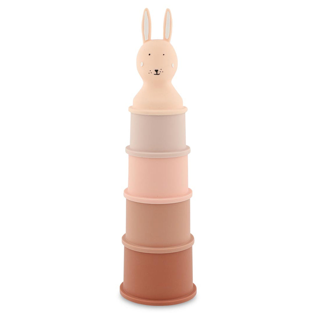Stack of five pastel-colored toy cylinders topped with a smiling rabbit head. The colors range from light pink to brown, creating a playful, gentle tone.