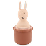 A set of pink nesting cups topped with a cute rabbit head. The rabbit has long ears, dotted eyes, and a small smile, creating a playful tone.