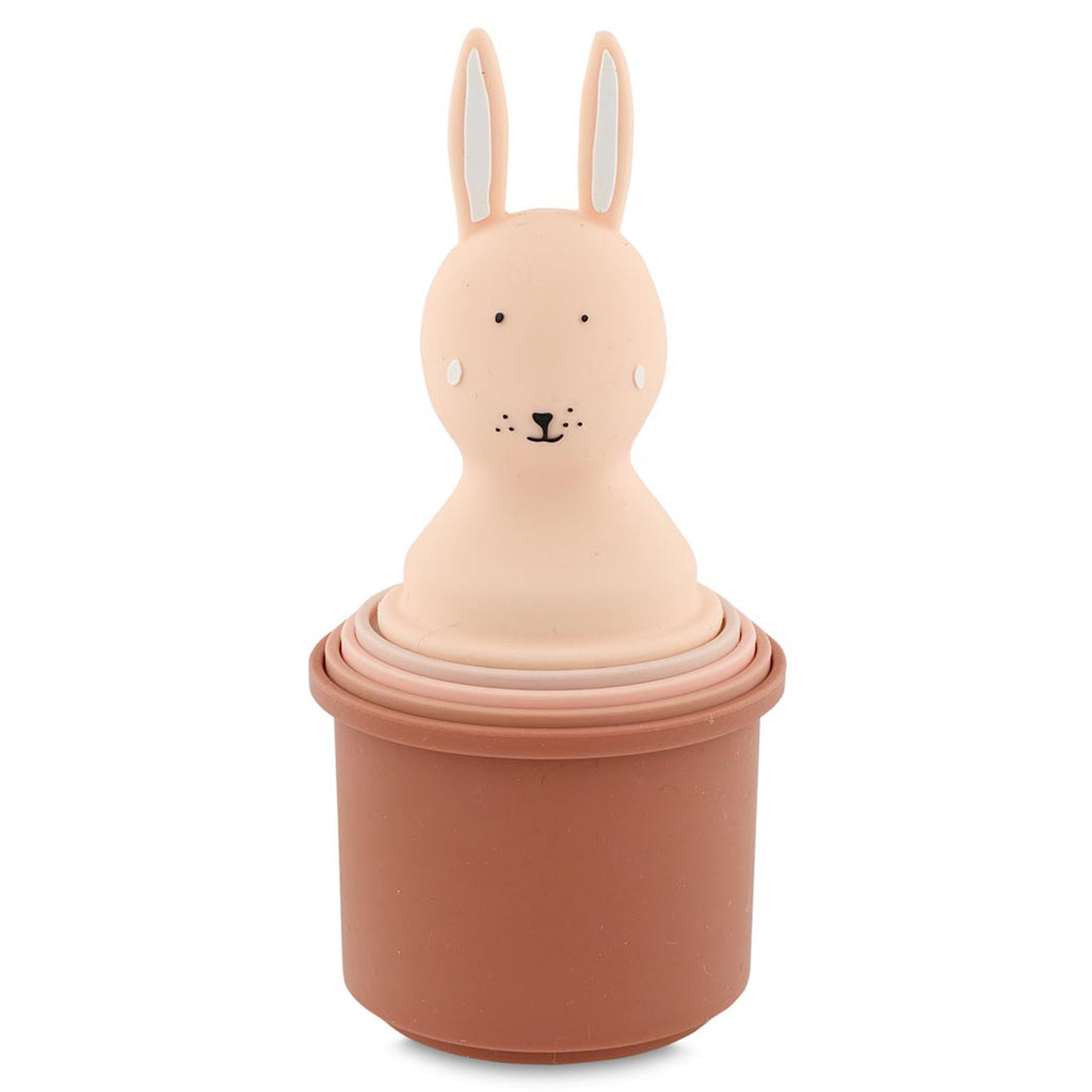 A set of pink nesting cups topped with a cute rabbit head. The rabbit has long ears, dotted eyes, and a small smile, creating a playful tone.