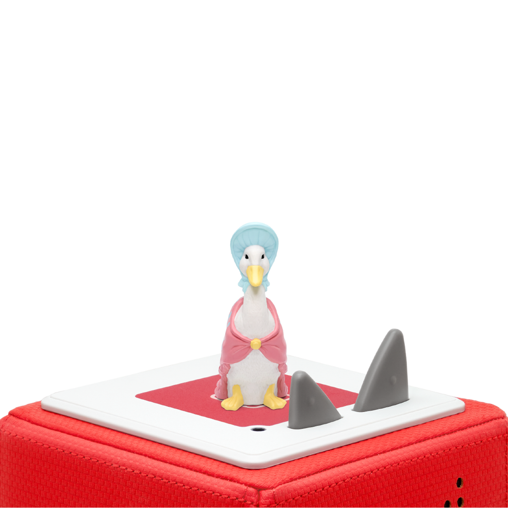 A whimsical duck figurine dressed in a pink cape and a light blue bonnet in a white background.