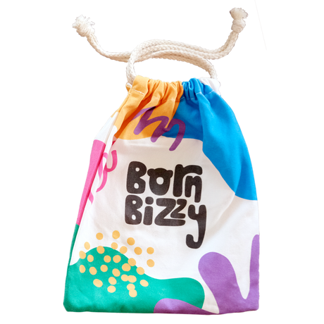 Colorful drawstring canvas bag with abstract shapes and the words "Born Bizzy" printed on the front.