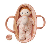 Olli Ella Dinky Dinkum doll with a pacifier lying in a pink corduroy doll bassinet, white background.