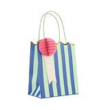 Blue and green striped party bag with a pink honeycomb paper rosette, scalloped gold edge, and light green handles.