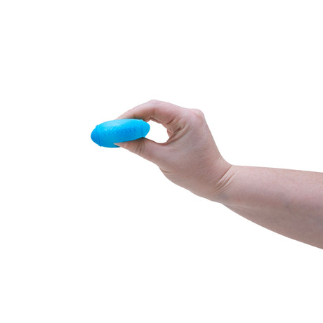 A hand squeezing a blue NeeDoh Hot Shots squishy football toy, demonstrating its small size and texture.