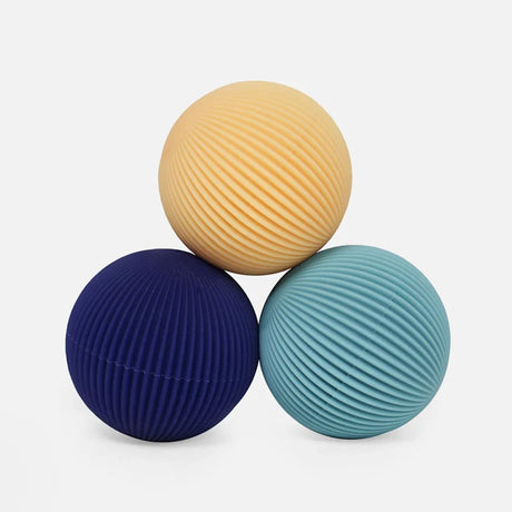 Three soft silicone Speks Odds fidget magnets in ridged yellow, navy blue, and teal.