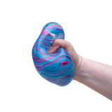 Hand squeezing a blue and pink NeeDoh Niceberg Swirl squishy stress ball toy.