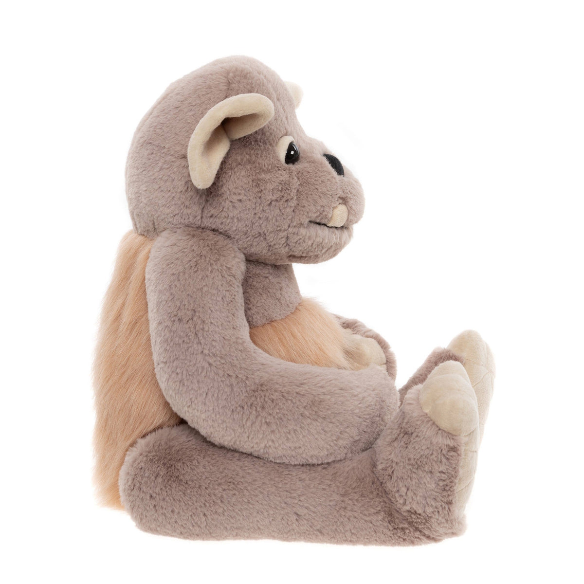 Side profile view of a soft grey plush monster toy seated with light brown fur on its back and stomach.
