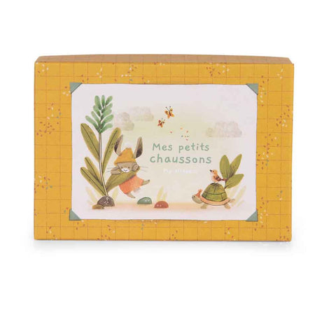 Yellow patterned gift box featuring an illustration of a rabbit and turtle with the French text "Mes petits chaussons."