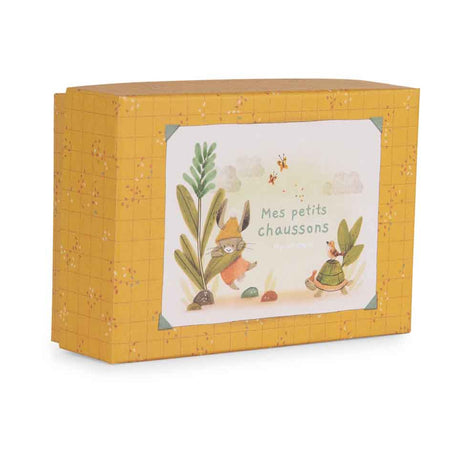 Yellow patterned gift box featuring a rabbit and turtle illustration with the text "Mes petits chaussons."