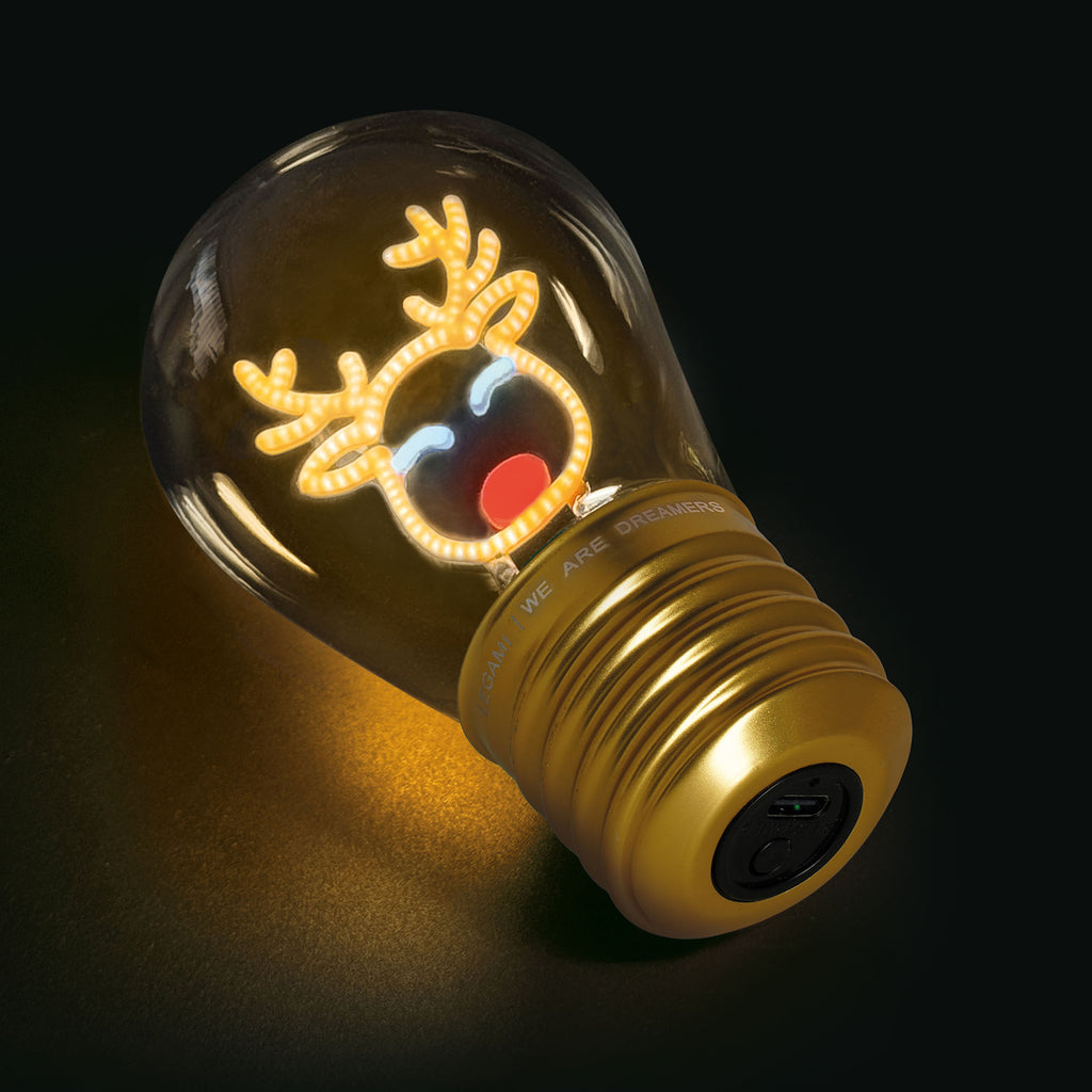 A light bulb with a glowing reindeer face design, including antlers and a red nose. The bulb emits a warm glow, creating a playful, festive mood.