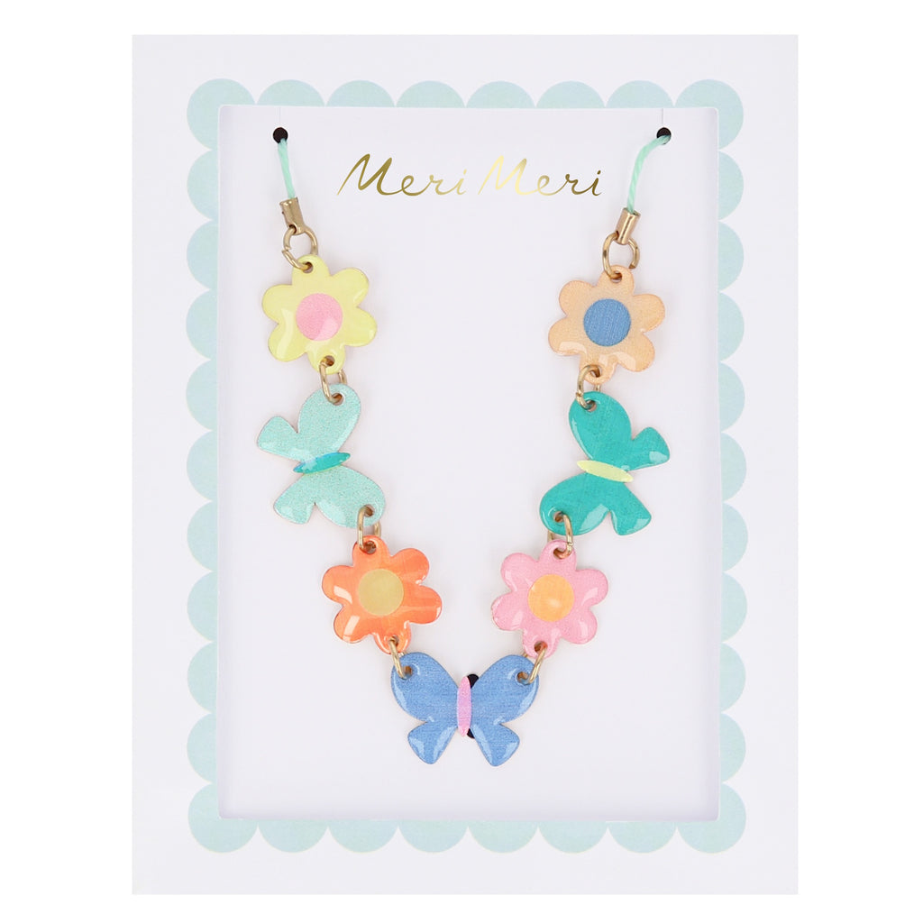 A delicate gold-tone necklace featuring colorful enamel butterfly and flower charms, perfect for a whimsical accessory.