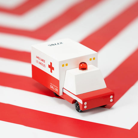 Minimalist wooden toy ambulance by Candylab Toys featuring a white and red Los Angeles design with a red emergency siren.