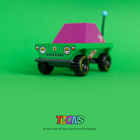 Green and purple Candylab Toons Dundee adventure truck toy with off-road tires against a solid green background.