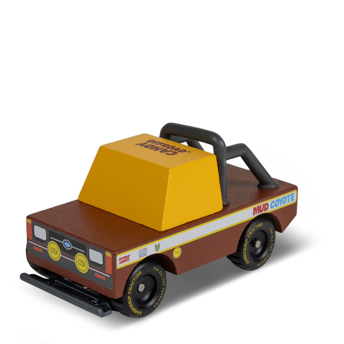 Wooden toy truck "Mud Coyote" by Candylab, featuring a brown body, yellow cab, and black off-road roll bar and tires.