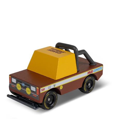 Wooden toy truck "Mud Coyote" by Candylab, featuring a brown body, yellow cab, and black off-road roll bar and tires.