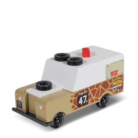 Candycar Gira Drifter wooden toy truck with giraffe print, white camper top, and spare tires on a white background.