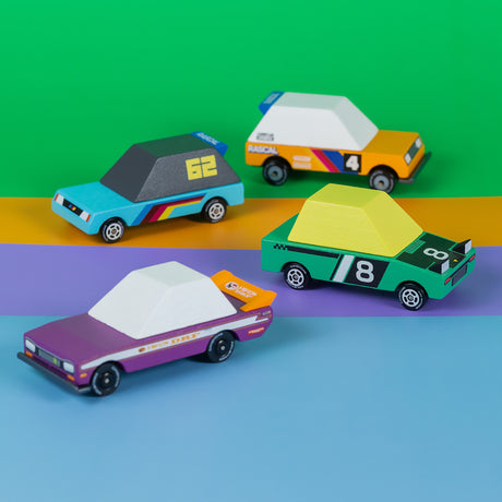 Four wooden Candycar toy race cars in vibrant colors with racing decals, arranged on a multi-colored background.
