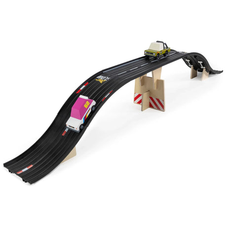 Wooden toy car bridge set with black rubber tracks, two minimalist toy cars, and light wood support blocks.