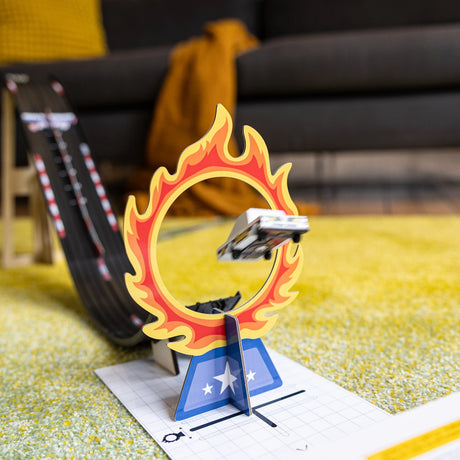Candylab Roadworks Stunt Jump playset featuring a toy car jumping through a flaming hoop on a yellow rug.