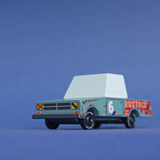 Candylab TOONS Rustoco wooden toy car with a teal body, rust-patina graphics, and racing number 6 on a blue background.