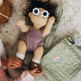 Dinkum Doll with sunglasses on a sage green convertible doll changing mat.