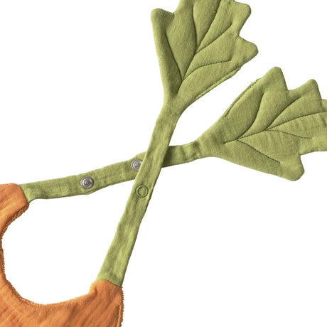 Close-up of a carrot-shaped baby bib with green leaf-shaped straps and snap fasteners on a white background.
