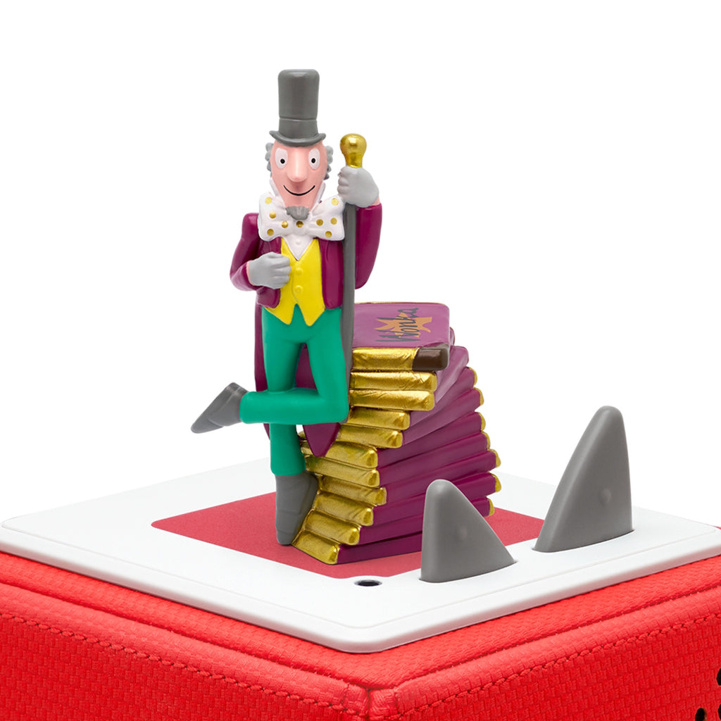 A whimsical figure of a smiling man in a top hat stands atop golden books.