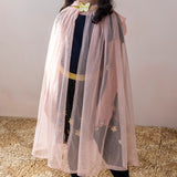 Child wearing a light pink glitter dress-up cape with a gold butterfly clasp and tulle mesh fabric.