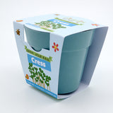 A blue bamboo plant pot packaged in a "Grow Your Own Cress" children's gardening kit cardboard sleeve.