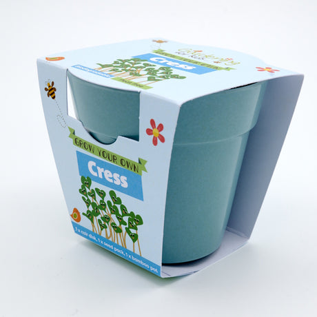 A blue bamboo plant pot packaged in a "Grow Your Own Cress" children's gardening kit cardboard sleeve.