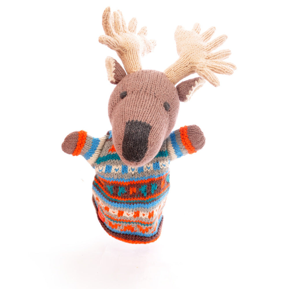 Knitted moose puppet with beige antlers and a brown snout, wearing a colorful patterned sweater in blue, red, orange, and white tones on a white background.