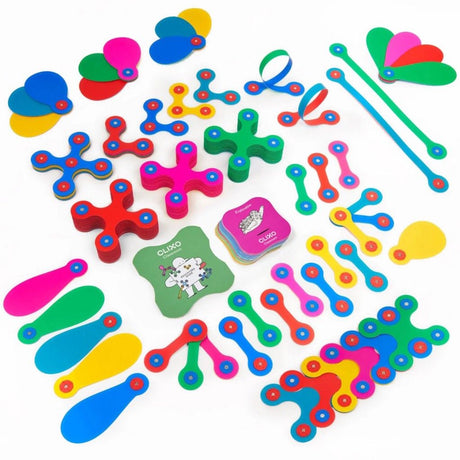 Colorful flexible building pieces with magnetic connectors, arranged neatly with cards on a white background.