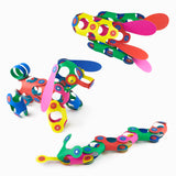 Three colorful 3D figures, including a dog and a snake, built from flexible magnetic toy pieces.