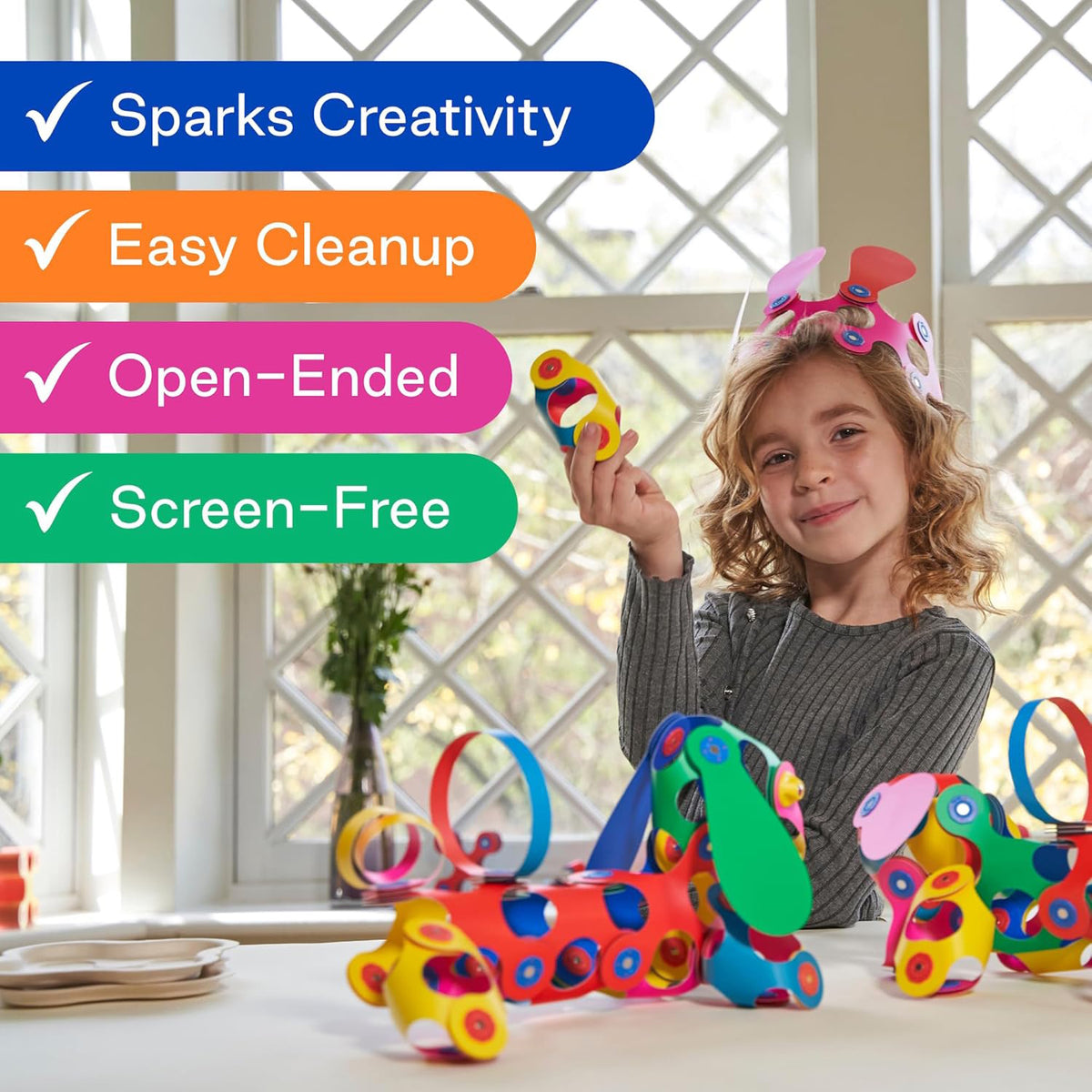 Young girl holding a flexible magnetic toy creation alongside colorful toy dogs and text overlay features.