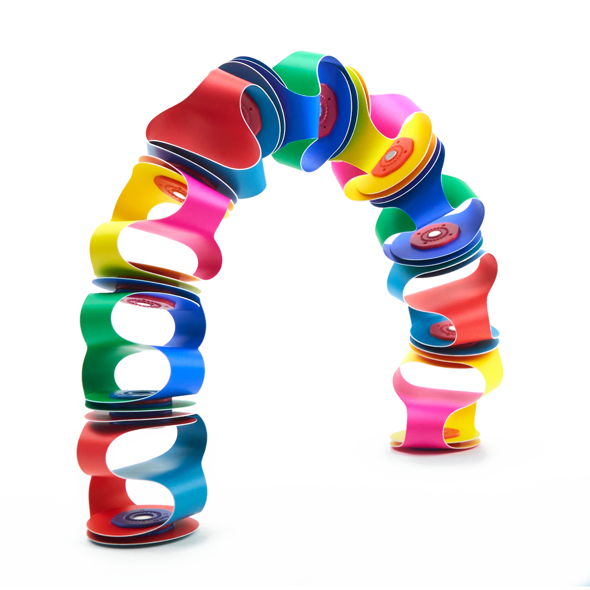 Colorful flexible magnetic toy pieces connected to form a vibrant, freestanding arch against a white backdrop.