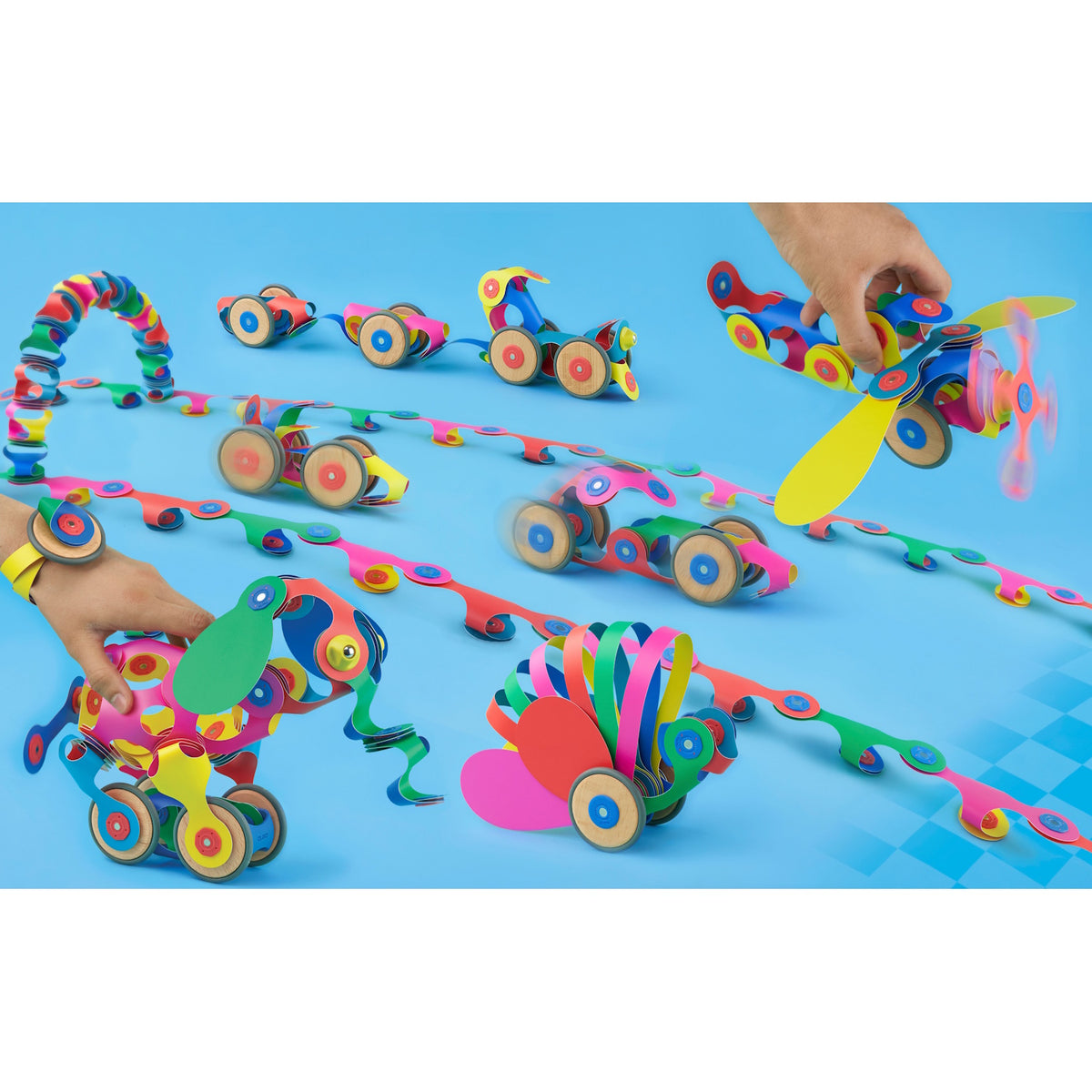 Colorful magnetic toy creations with wheels, including vehicles, an airplane, and an elephant, on a blue background.