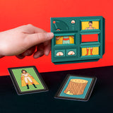 A hand holds a card with cutouts resembling a control panel, revealing parts of a superhero illustration. Two other cards show a superhero and a log on a black and red background. The tone is playful and colorful.