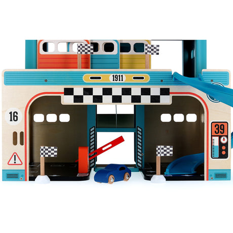 Wooden toy car garage playset with a blue car, racing flags, and a red barrier gate. Perfect for toddler imaginative play.