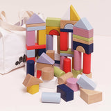 Colorful wooden building blocks in various geometric shapes with a white canvas storage bag.