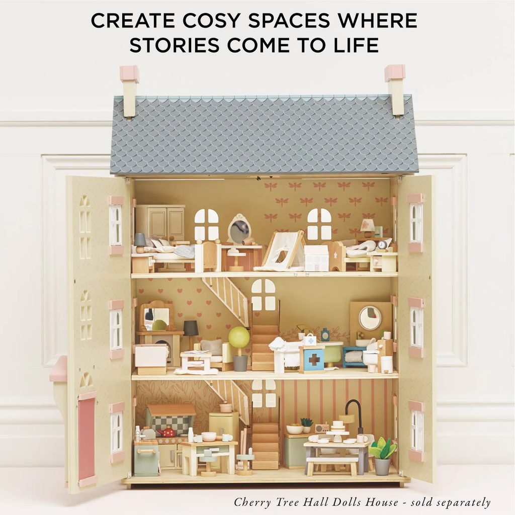 Open wooden dollhouse with three floors, each decorated with miniature furniture and accessories. Text above reads, "CREATE COSY SPACES WHERE STORIES COME TO LIFE."