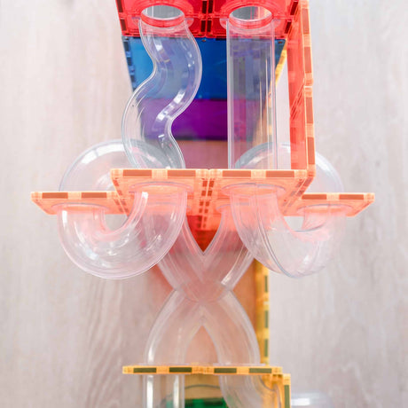 Close-up of a colorful magnetic tile ball run featuring clear plastic tubes, twists, and loops.