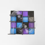 Top-down view of a square magnetic tile ball run built with glittery purple, blue, and black tiles.