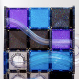 Glittery blue, purple, and black magnetic tiles with clear ball run tubes attached.