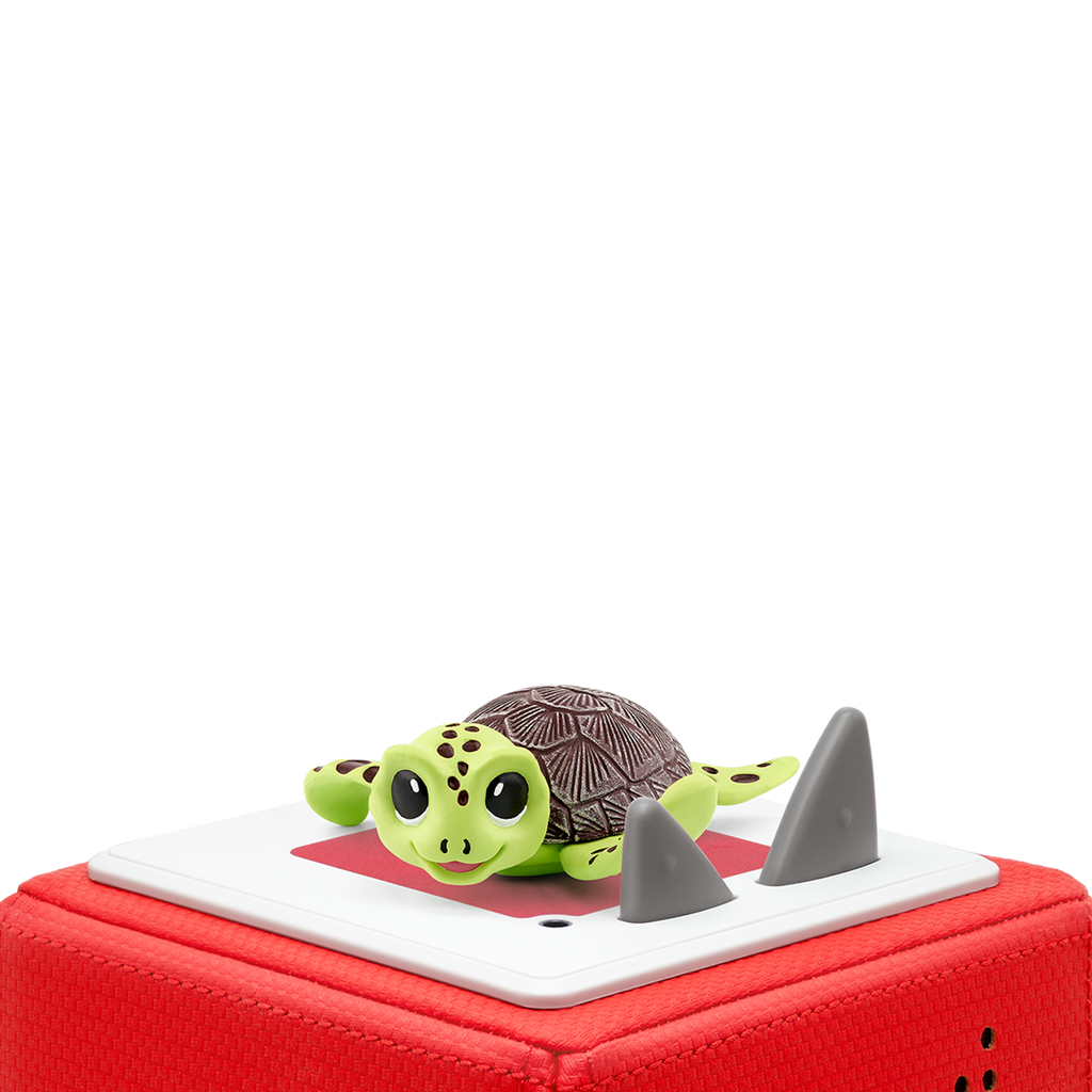 A vibrant green turtle toy sits atop a red block, featuring a textured shell.