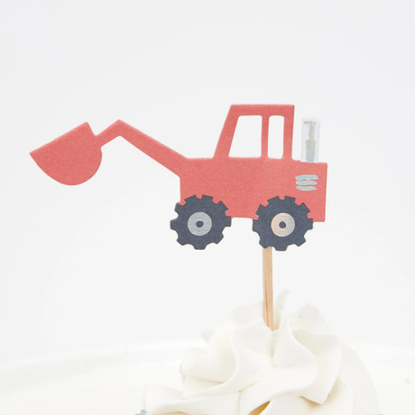 Red excavator cupcake topper with a front loader scoop on a wooden pick in swirled white frosting.