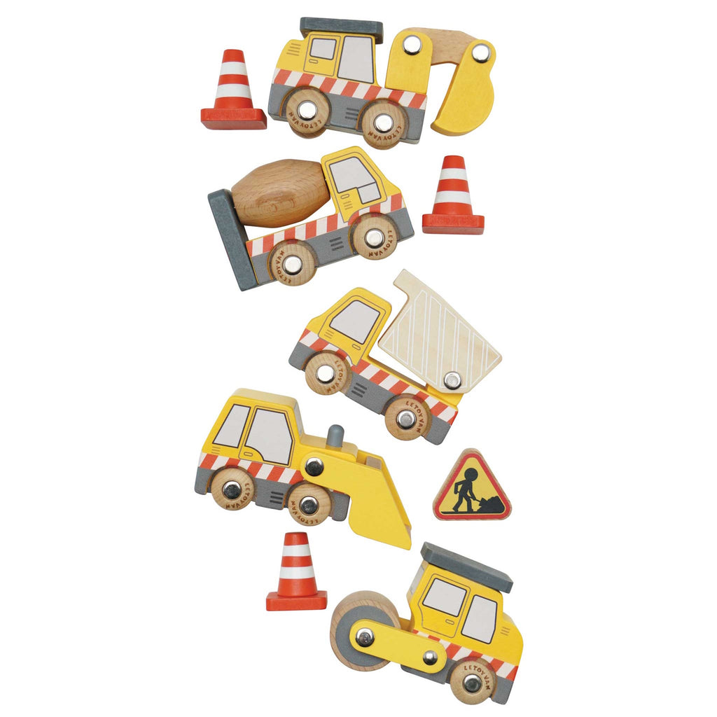 Wooden toy construction vehicles, including a dump truck, excavator, road roller, and cement mixer, are surrounded by traffic cones and a caution sign.