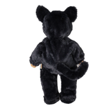 Back view of a plush doll in a fuzzy black cat suit with cat ears and a long tail.