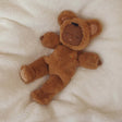 Olli Ella Cozy Dinkum Teddy Mini Caramel doll sleeping on a soft white blanket.