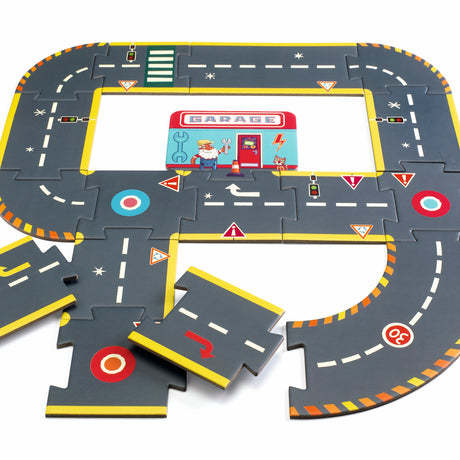 Children's puzzle road set with interconnected pieces showing roads, traffic signs, and a garage illustration. Vibrant and playful design.