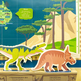 Close-up of a dinosaur map featuring standing paper figures of a green T-Rex and an orange Triceratops.